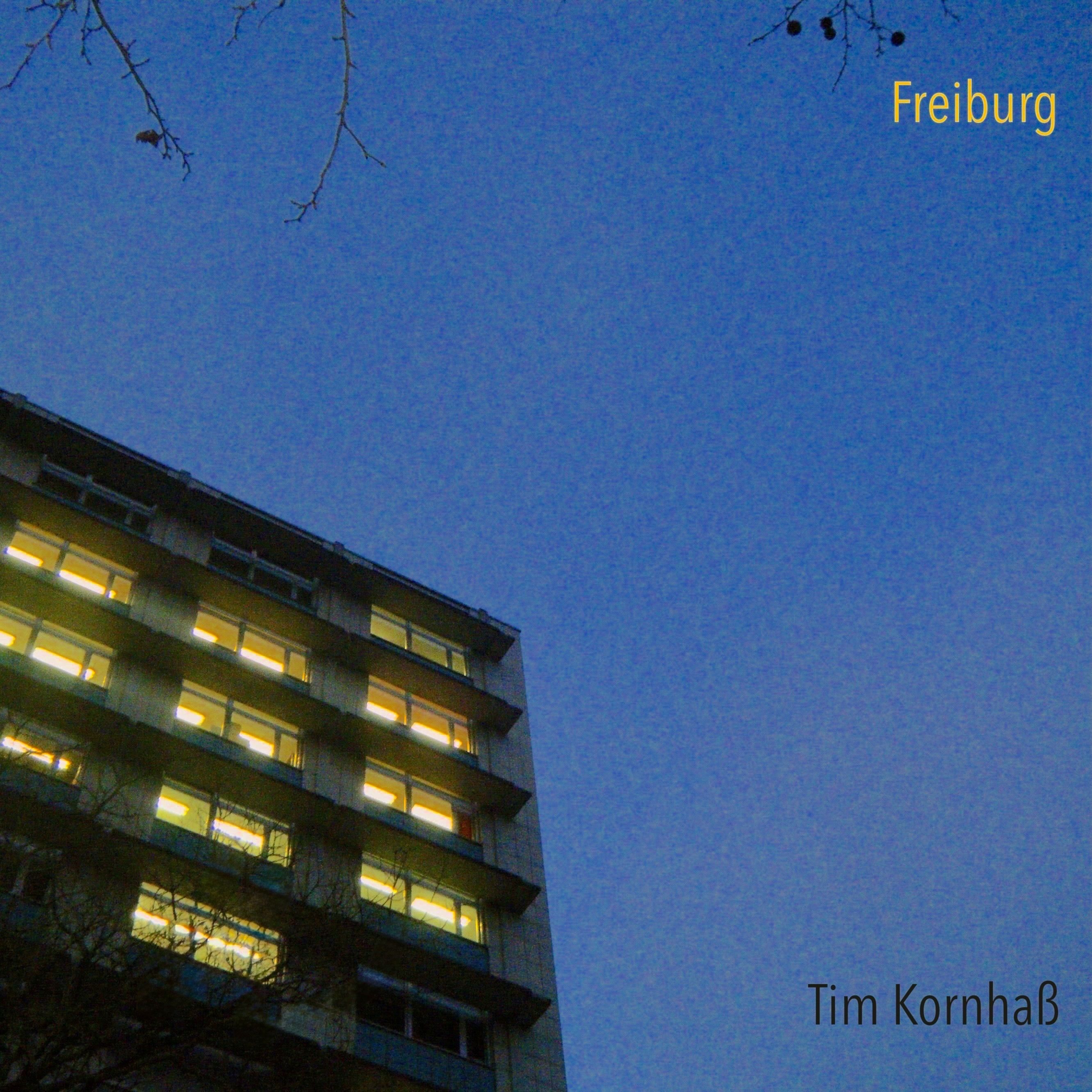 A white standup piano, equipped with two mircrophones for recording.